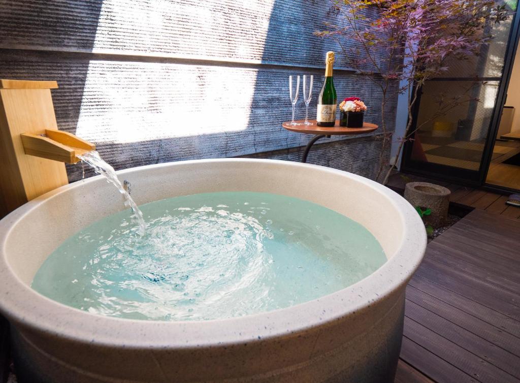 una bañera llena de agua con una botella de vino en Kiraku Kyoto Gion, en Kioto