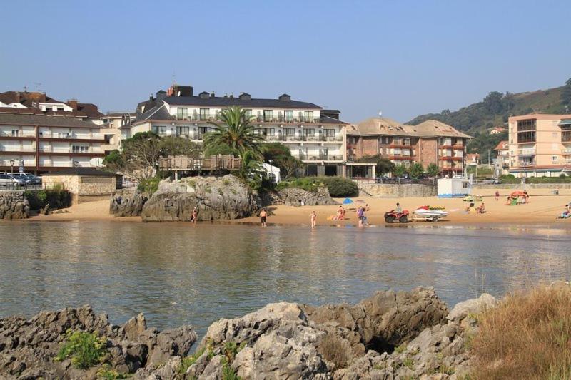 un grupo de personas en una playa con edificios en Hotel Alfar, en Isla