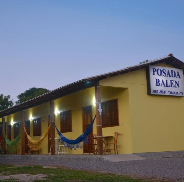 a yellow building with hammocks in front of it at Pousada Balen in Pântano Grande