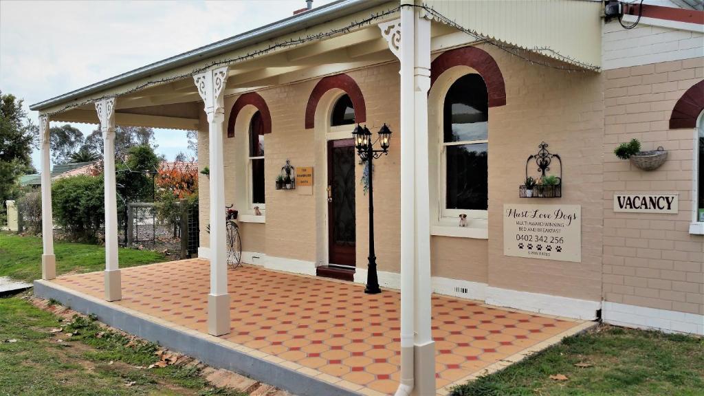 een veranda aan de voorzijde van een huis met een bakstenen patio bij Must Love Dogs B&B & Self Contained Cottage in Rutherglen