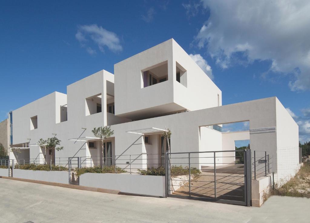 a white house on the side of a road at Vitorno Residence in San Vito lo Capo