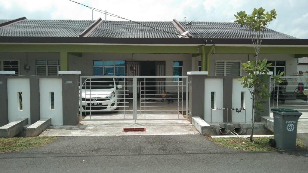 een huis met een auto ervoor geparkeerd bij Ainur Homestay in Melaka