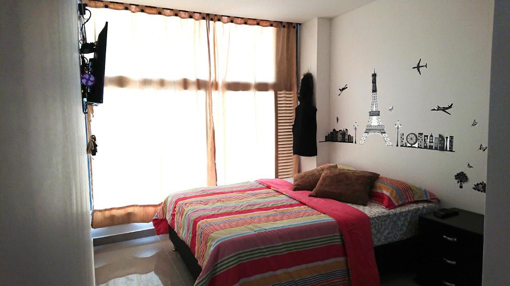 1 dormitorio con cama y ventana grande en Apartasuites Medellin Los Molinos, en Medellín