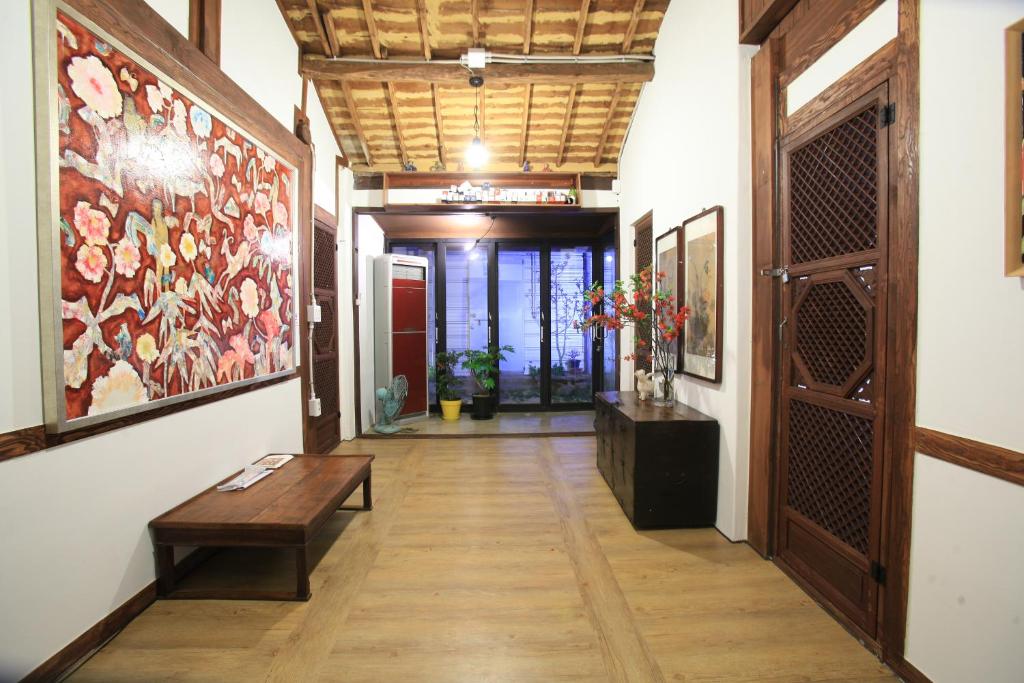 a hallway with a bench and a painting on the wall at MongYouHwaWon Guesthouse(Painter's house) in Jeonju