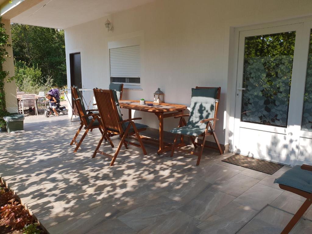 a wooden table and chairs on a patio at Apartman Nicolle in Krk
