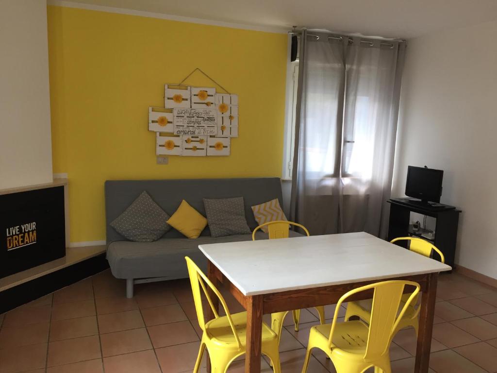 uma sala de estar com uma mesa e cadeiras amarelas e um sofá em Casa Anna em Montesilvano