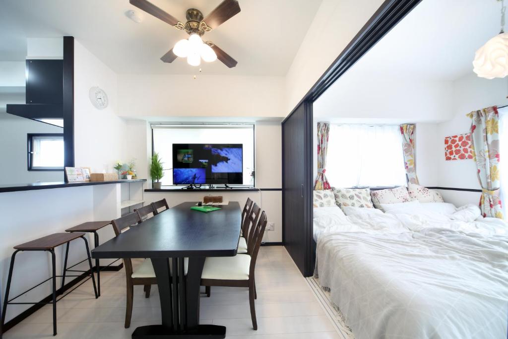 - une chambre avec un lit, une table et des chaises dans l'établissement EX Itoman Apartment 801, à Itoman