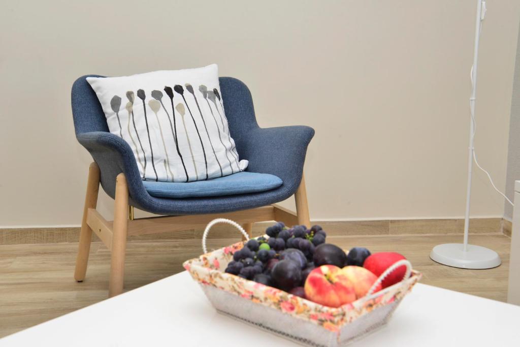 a basket of fruit on a table next to a chair at Apartman Bradasevic Tivat in Tivat