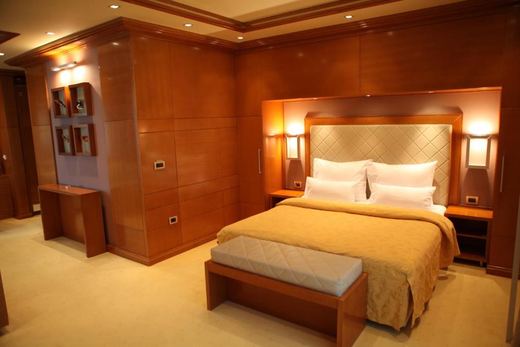 um quarto com uma cama grande e paredes de madeira em Garni Hotel Aleksandar em Novi Sad
