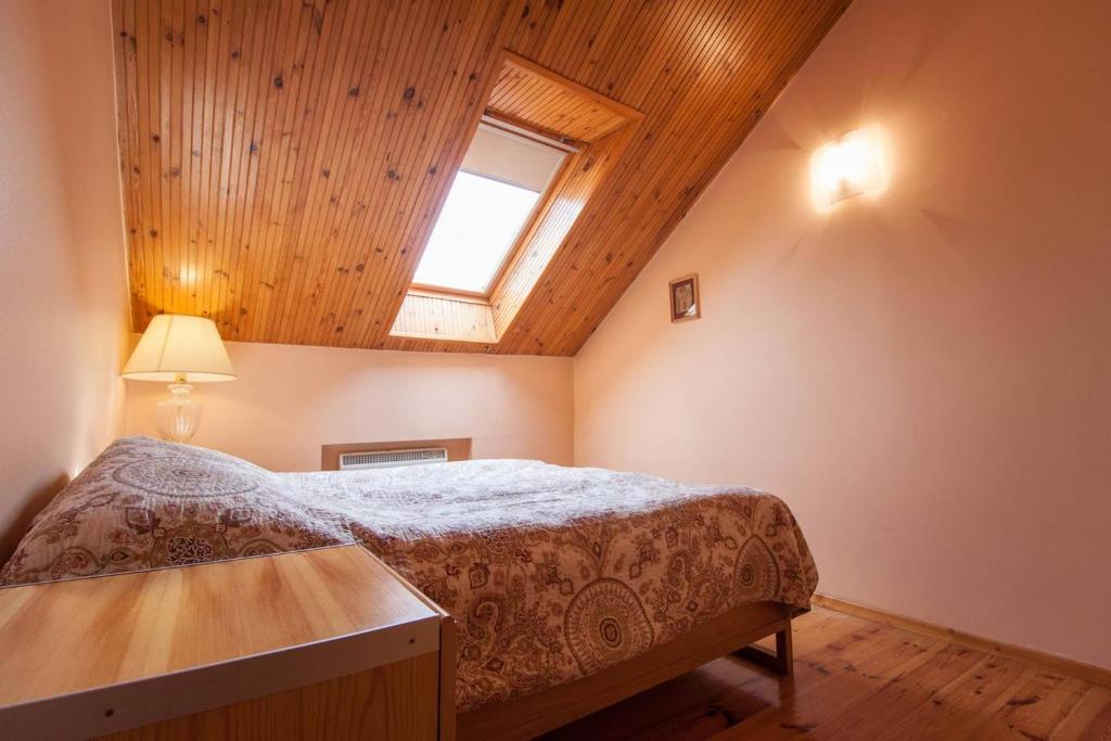 a bedroom with a bed with a wooden ceiling at Apartment Vokiečių in Vilnius