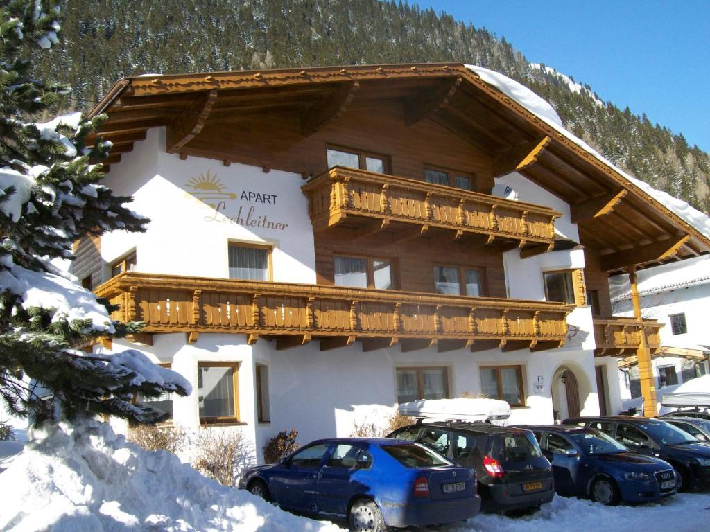 a large building with cars parked in front of it at Apart Lechleitner in Ischgl