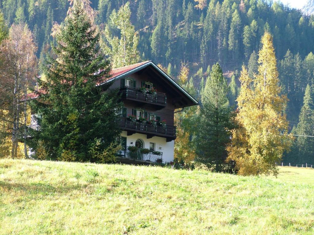 una casa in cima a una collina in un campo di Landhaus Kaulfuss a Sankt Jakob in Defereggen