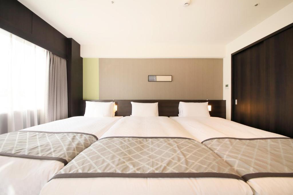 Postel nebo postele na pokoji v ubytování Richmond Hotel Higashi Osaka