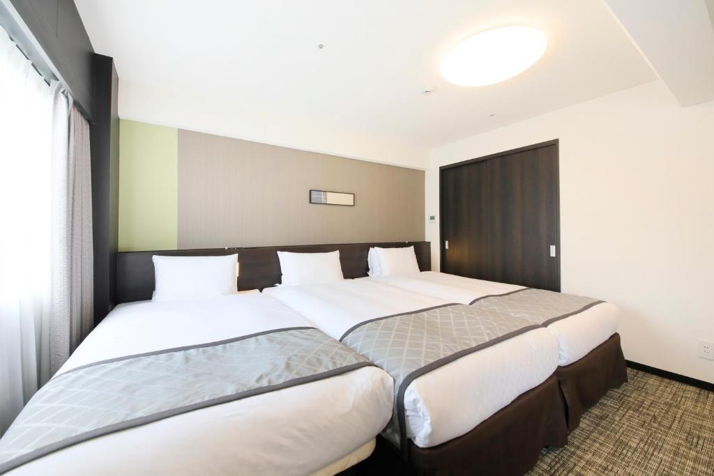 Postel nebo postele na pokoji v ubytování Richmond Hotel Higashi Osaka