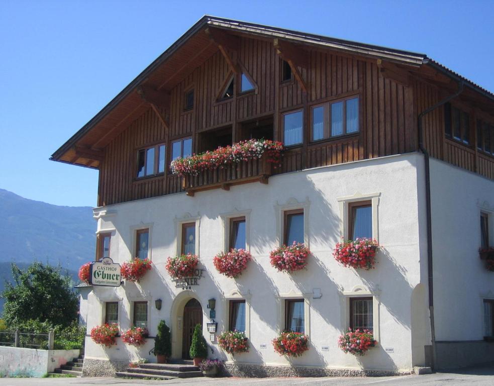 un grande edificio bianco con fioriere sopra di Gasthof Ebner ad Absam