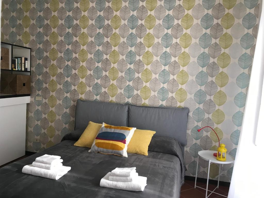 1 dormitorio con cama gris y pared en Valerie House en Milán
