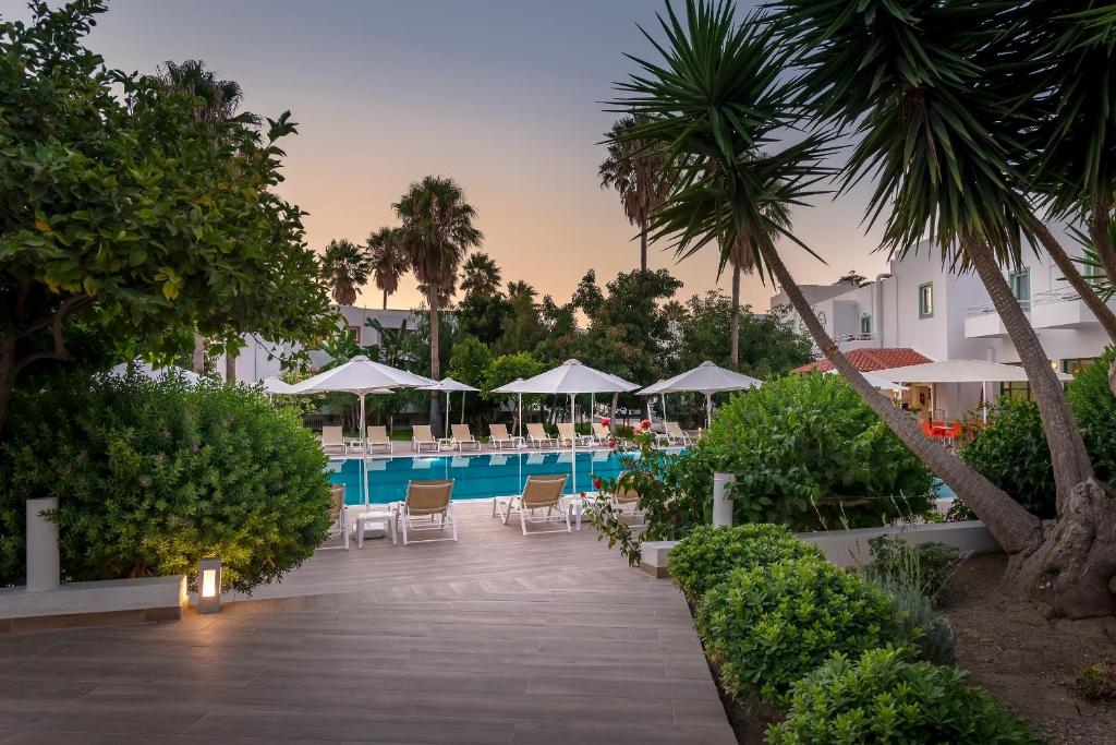 einen Pool im Resort mit Stühlen und Sonnenschirmen in der Unterkunft Alexandra Beach in Kos-Stadt