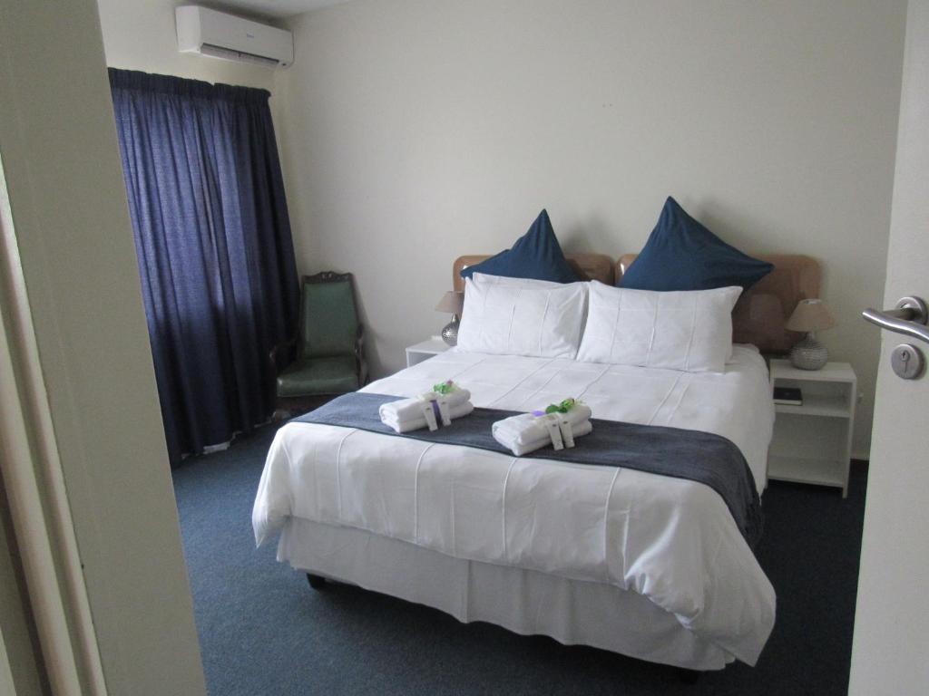 a bedroom with a large bed with towels on it at Concord Christian Guesthouse in Durban