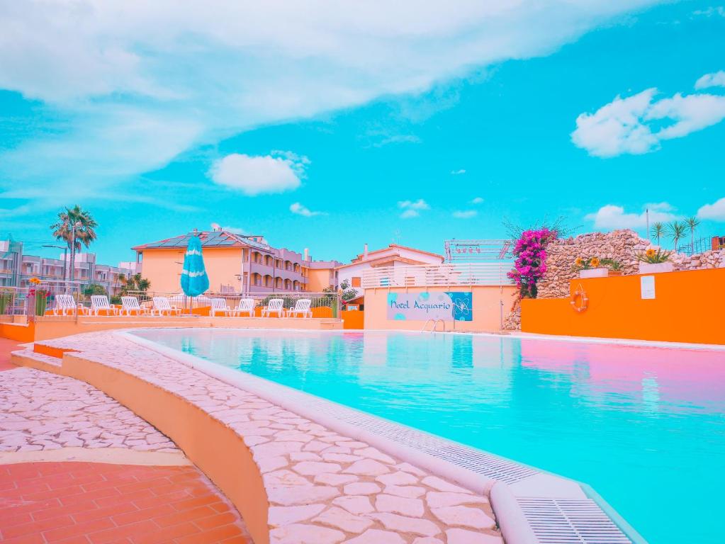 a swimming pool with blue water in a resort at Hotel Acquario in Campomarino