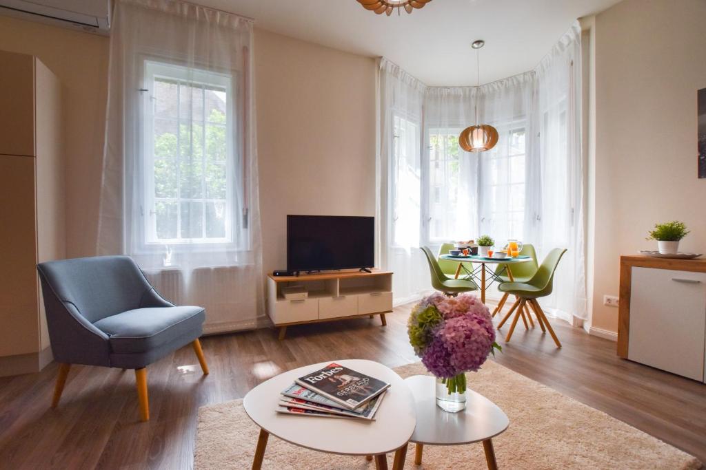 un salon avec une chaise bleue et une télévision dans l'établissement Christine Apartment close to the Buda Castle, à Budapest