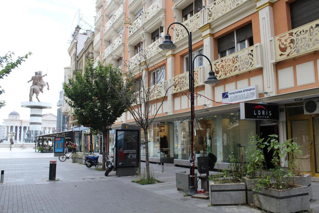 una calle en una ciudad con una estatua en el fondo en A&B apartment, en Skopje