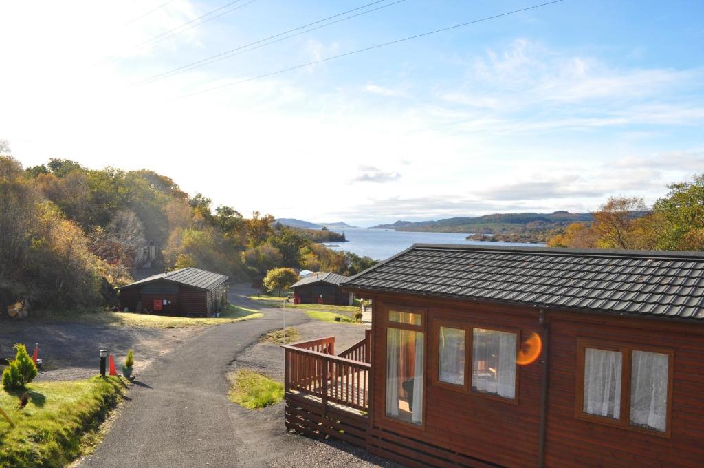 a cabin on the side of a road next to a lake at West Loch Shores in Tarbert