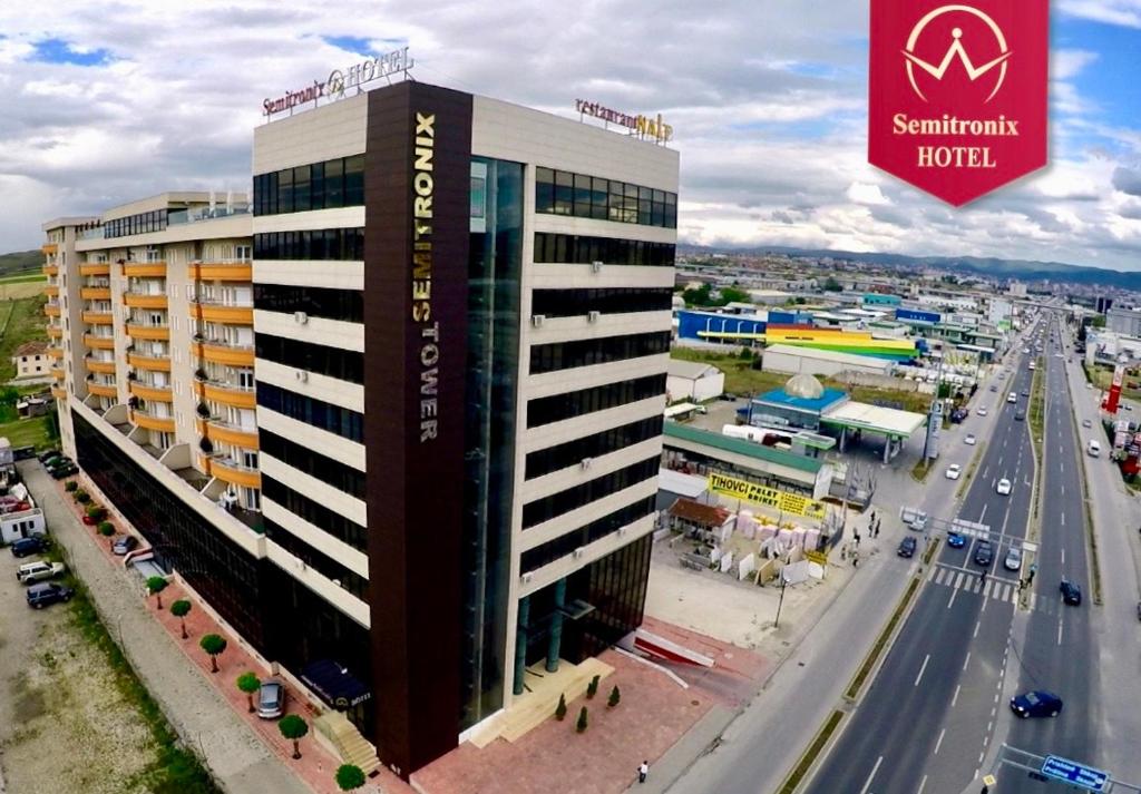 a building with a sign on it next to a highway at Semitronix Hotel Prishtina in Pristina