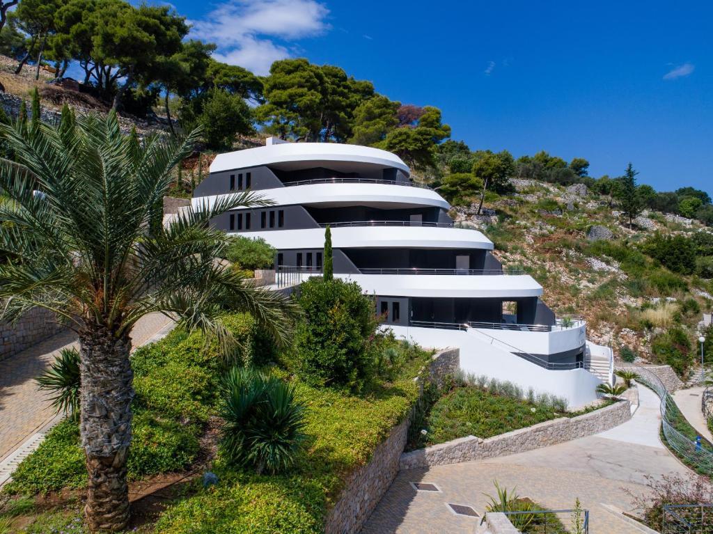 ein Haus auf einem Hügel mit einer Palme in der Unterkunft RMH Lazure Luxury Apartments in Lopud Island