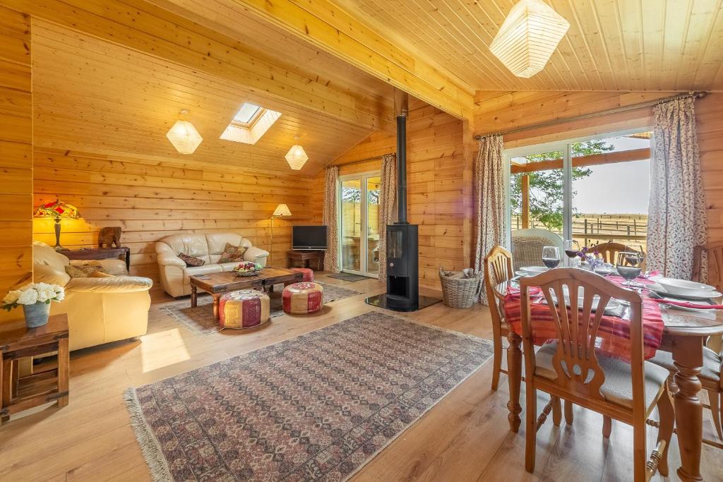 a living room with wooden walls and a table and chairs at The Lodge in Stowmarket