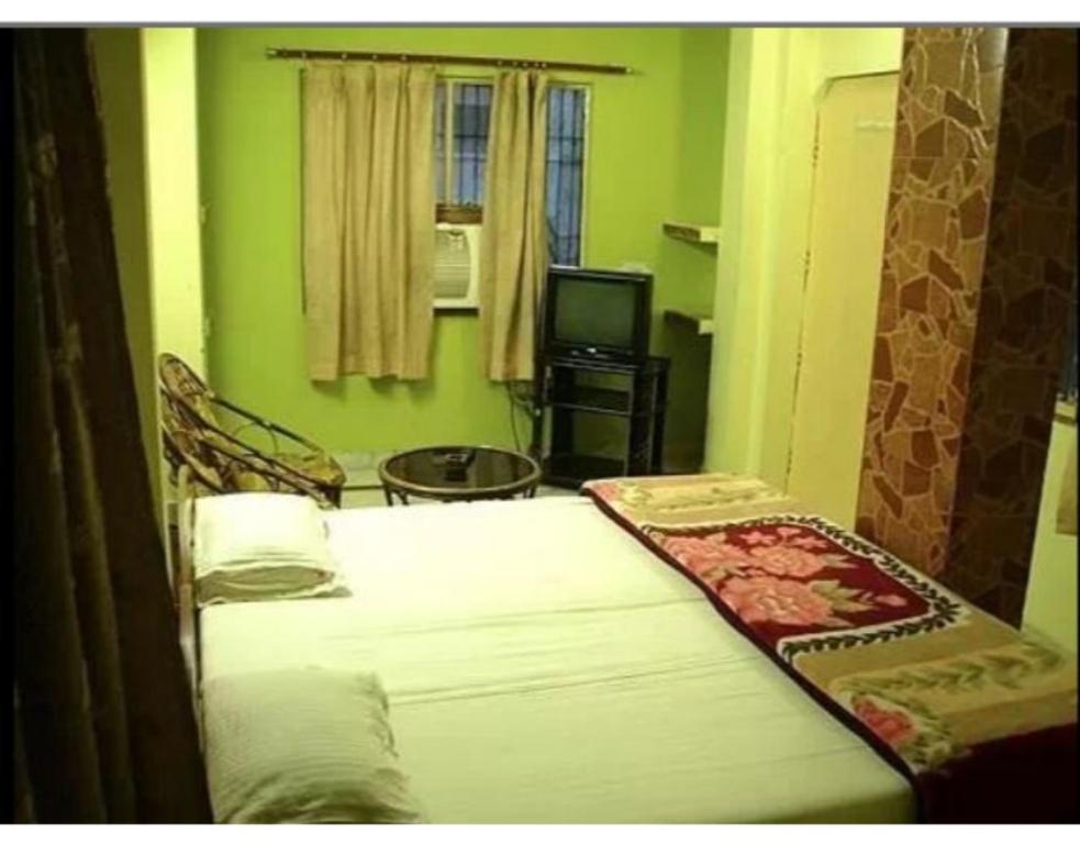 a bedroom with two beds and a television in a room at Hotel Divya in Rishīkesh