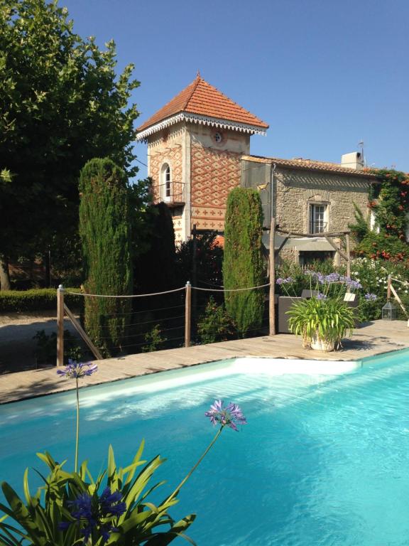 a house with a swimming pool in front of a house at Le Pigeonnier gîte privé climatisé avec piscine couverte et chauffée plus SPA in Alzonne