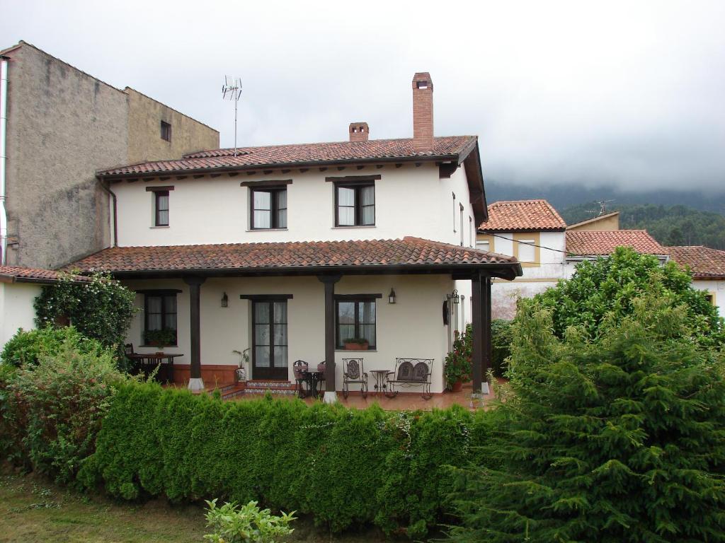 una casa blanca con una valla y árboles en Casa de Aldea Los Duesos, en Caravia