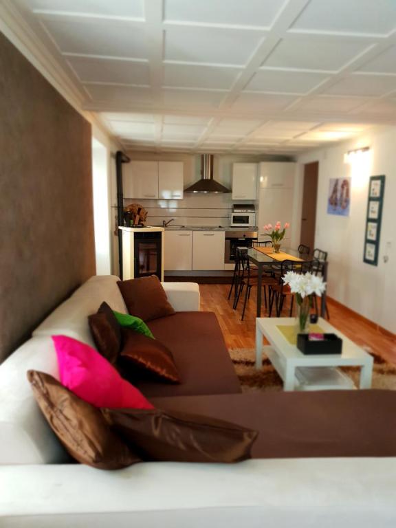 ein Wohnzimmer mit einem weißen Sofa und einer Küche in der Unterkunft Appartamento via Luina in Airolo