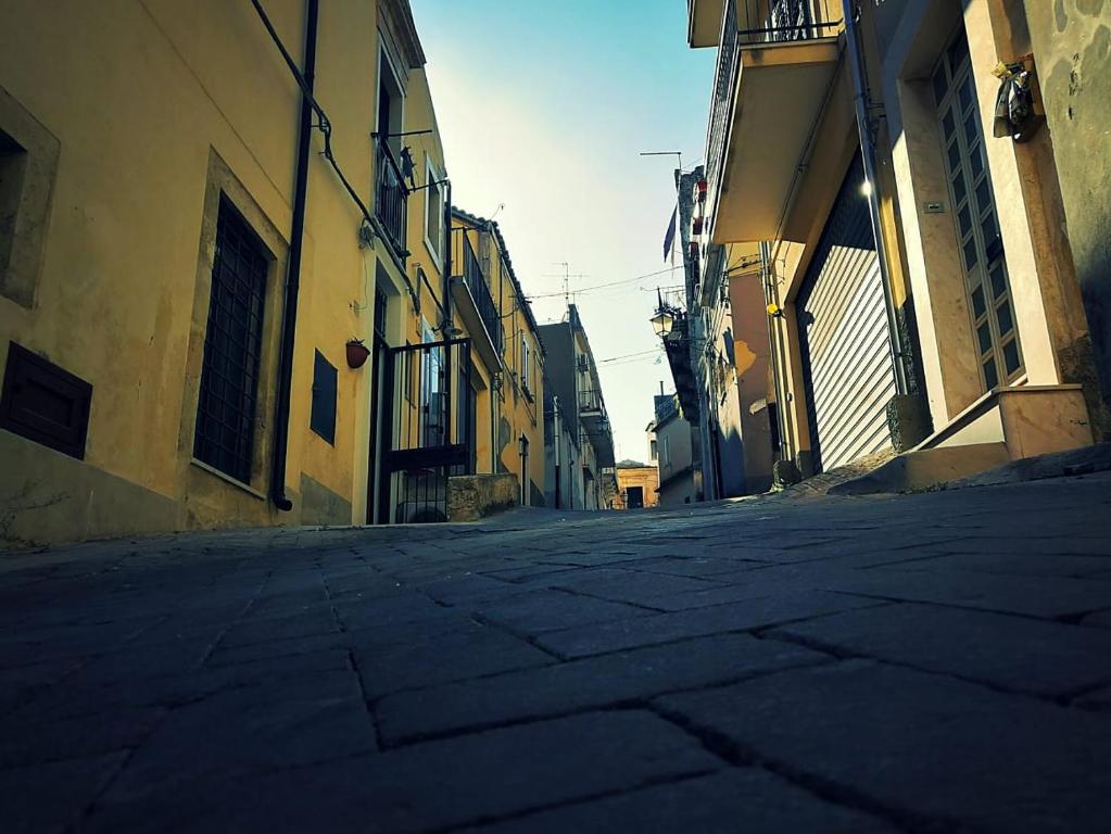 een lege straat in een steegje tussen gebouwen bij U dammusu ra cianta in Modica