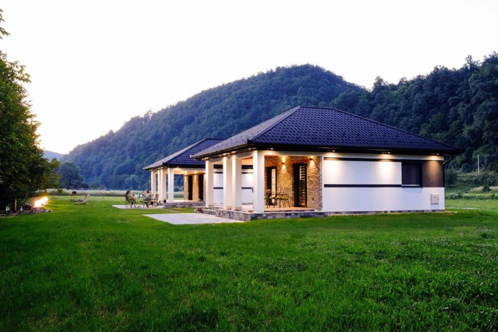 a small house in a field with a green field at Holiday home Green coast in Bosanska Krupa