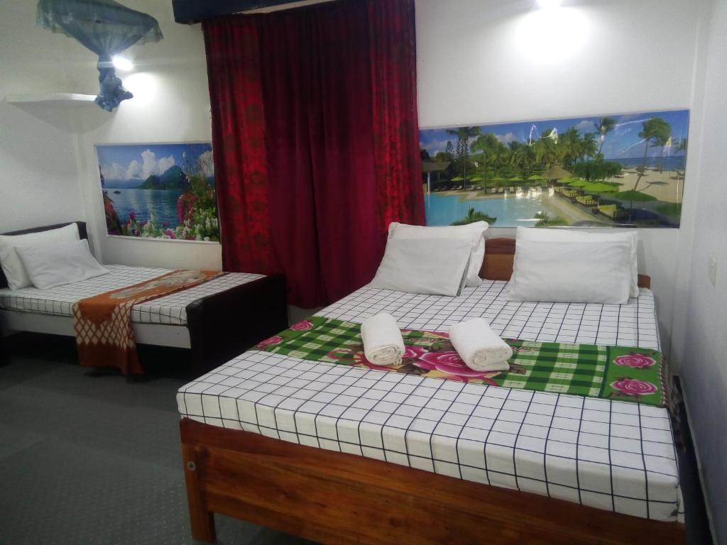 a room with two beds and a painting on the wall at Erandi Holiday Home in Andiambalama
