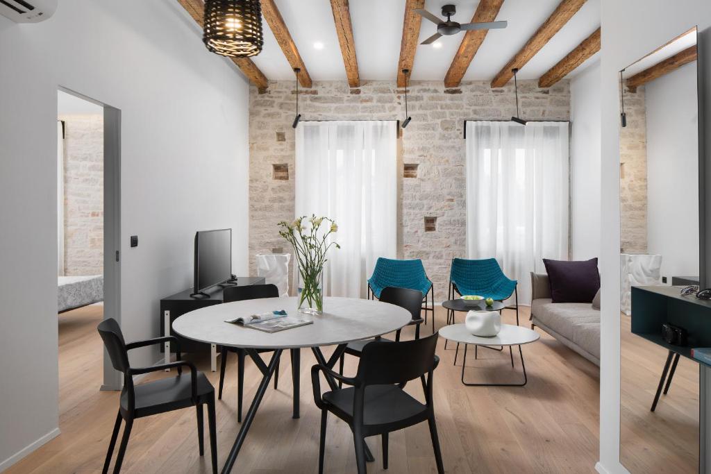 a living room with a table and chairs and a couch at Apartment Fianona - Rovinj city center in Rovinj