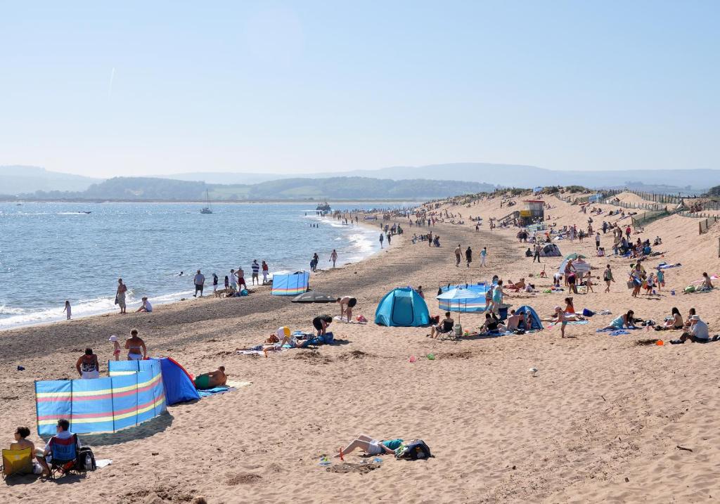 un grupo de personas tumbadas en una playa en Summerwind Guest House en Exmouth