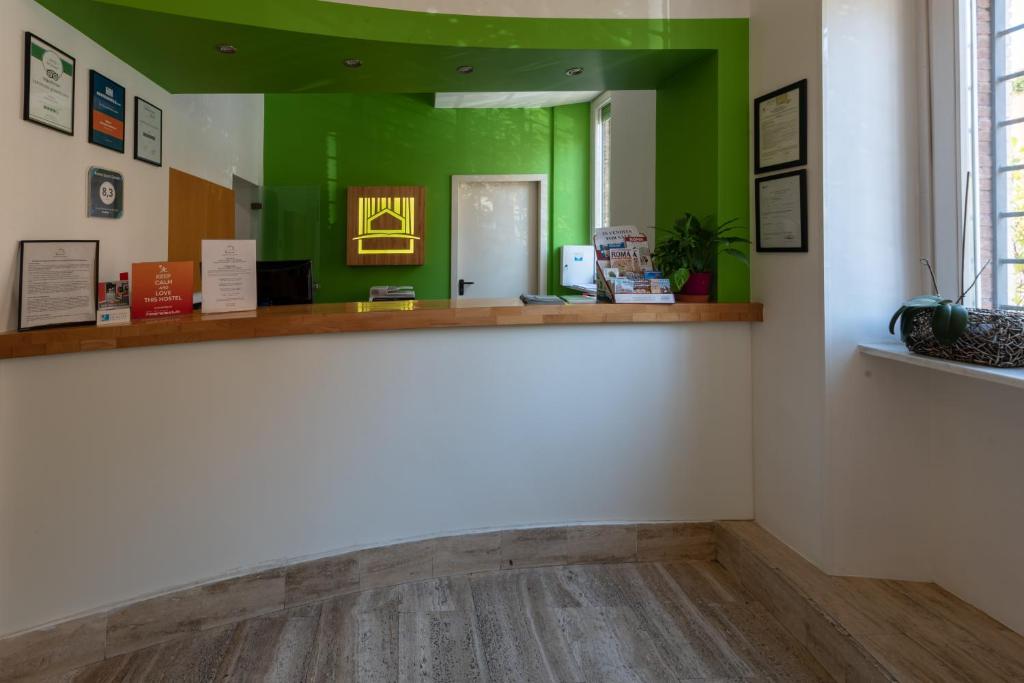 um quarto com paredes verdes e piso em madeira em Roma Scout Center em Roma