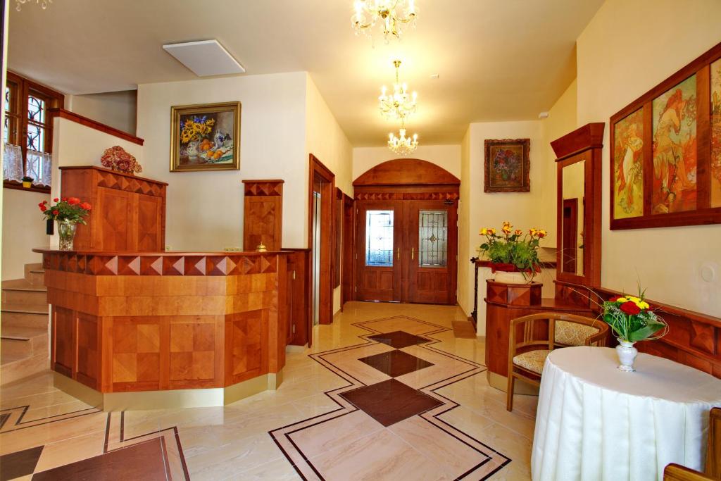 a room with a hallway with a table and chairs at Hotel Fortna in Chrudim