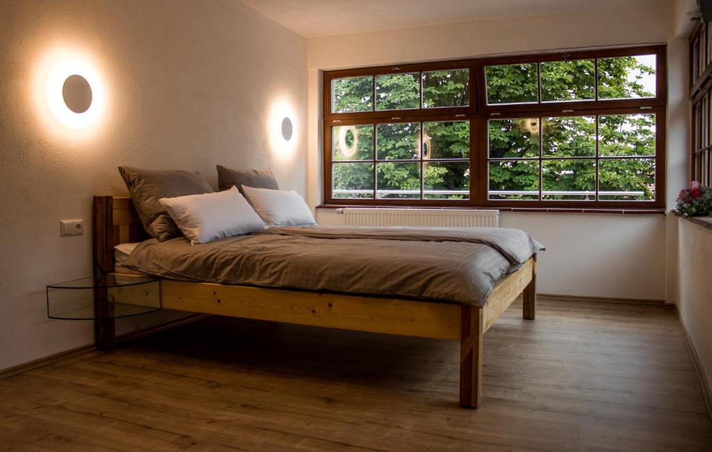 a bed in a room with a large window at Wirgarten Antik Hotel in Dingolfing