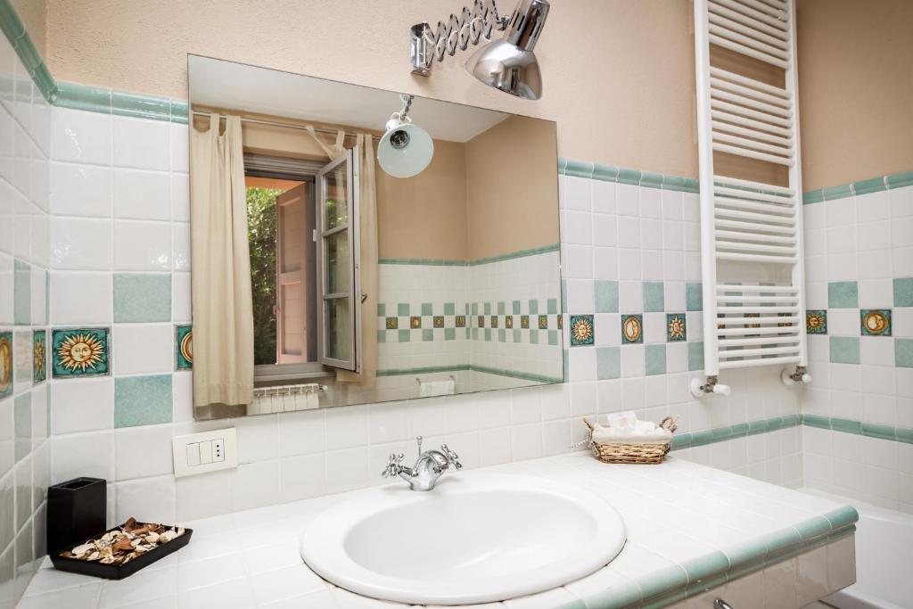 bagno con lavandino e specchio di Antica Pinciana Agriturismo a Capalbio