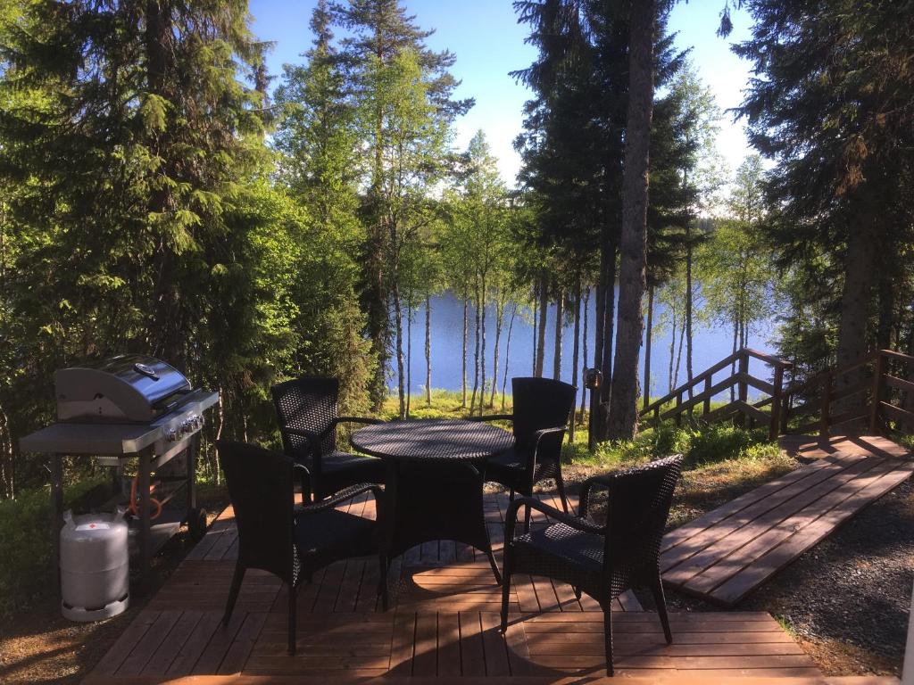 a patio with a table and chairs and a grill at Villa Saaruanniemi B in Ruka