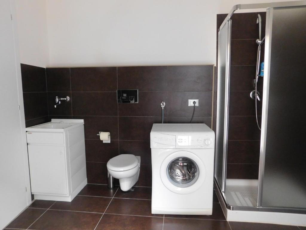 a bathroom with a washing machine and a toilet at Corte dei medici - Palace in Catania