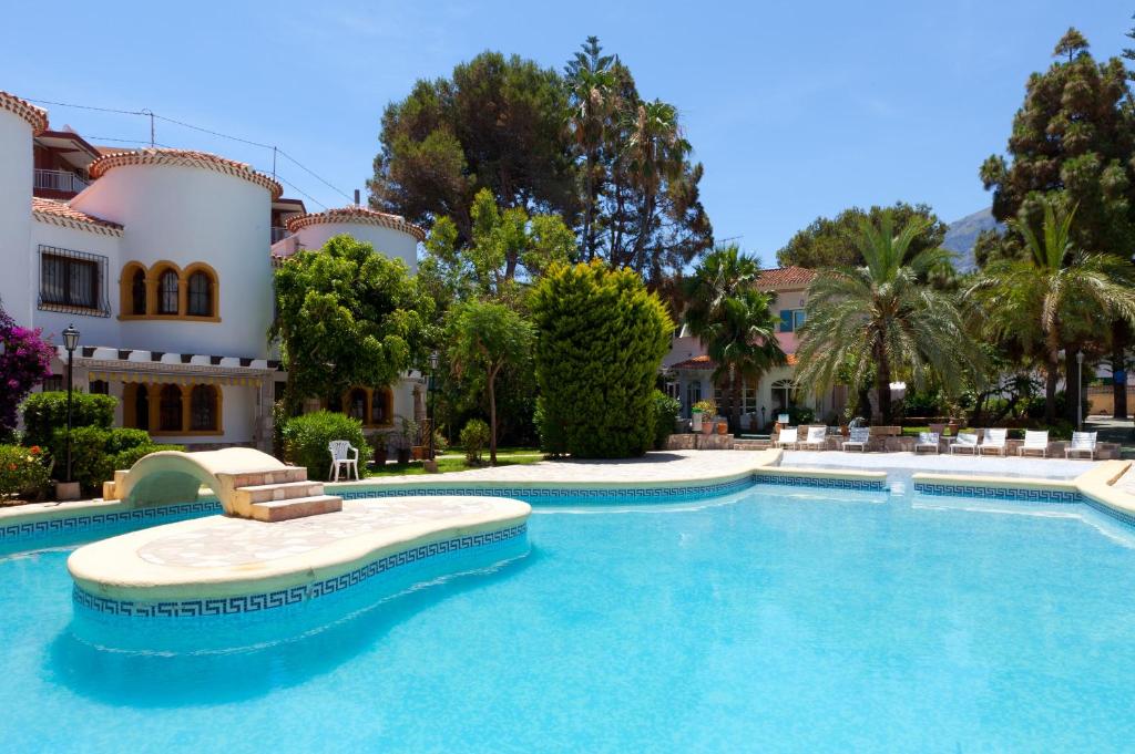 a swimming pool in front of a house at MR Hotelet de la Raconà & Apartments in Denia