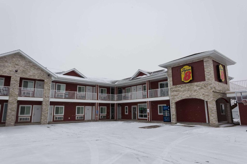 an empty parking lot in front of a building at Super 8 by Wyndham Watrous in Watrous
