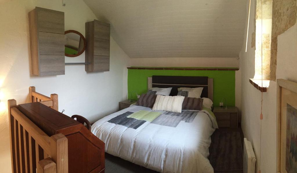 1 dormitorio con 1 cama con pared verde en Gîte Le Cézan en Jégun