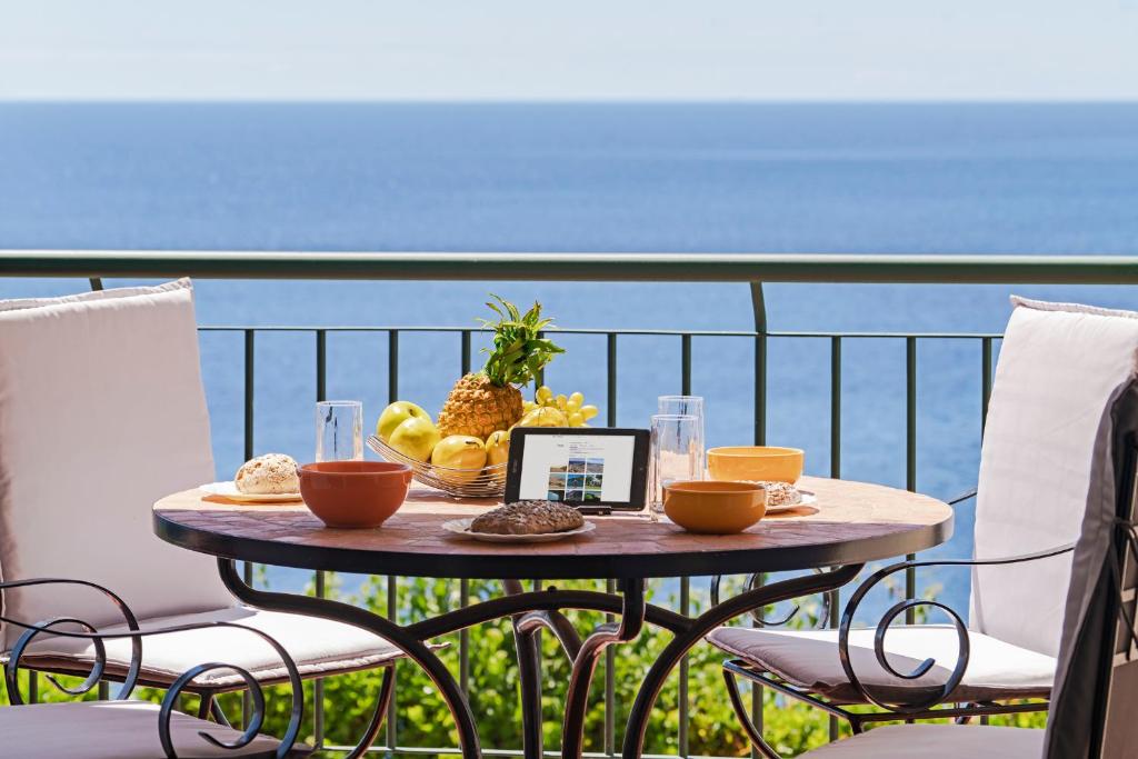 una mesa con un plato de comida en la parte superior de un balcón en Reis Magos II by An Island Apart, en Caniço