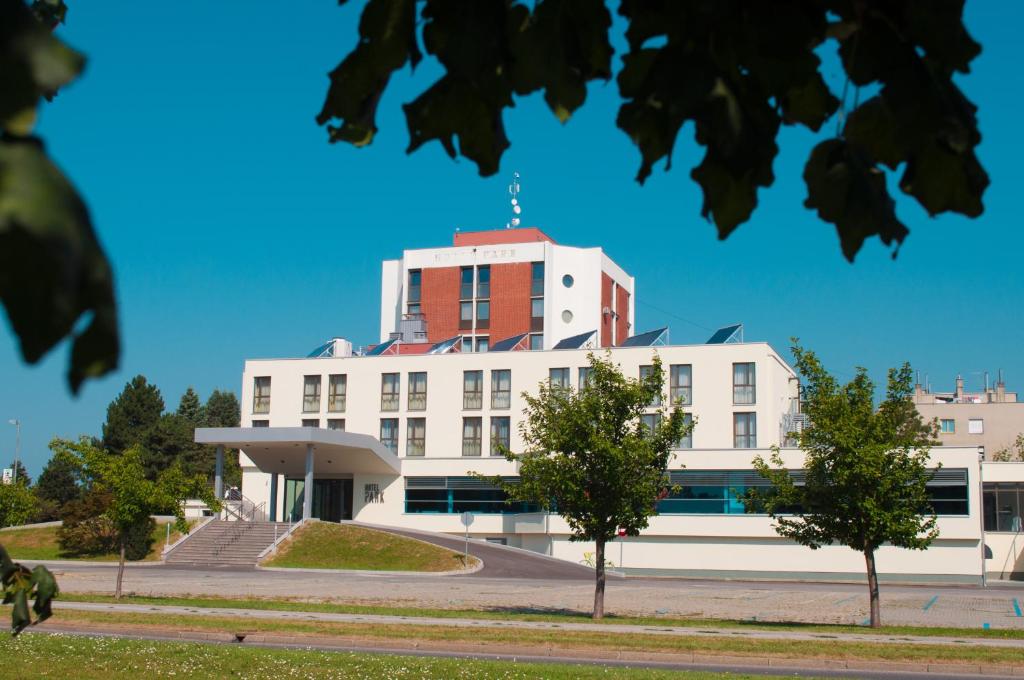 um grande edifício branco com um telhado vermelho em Hotel Park Superior 3* em Čakovec