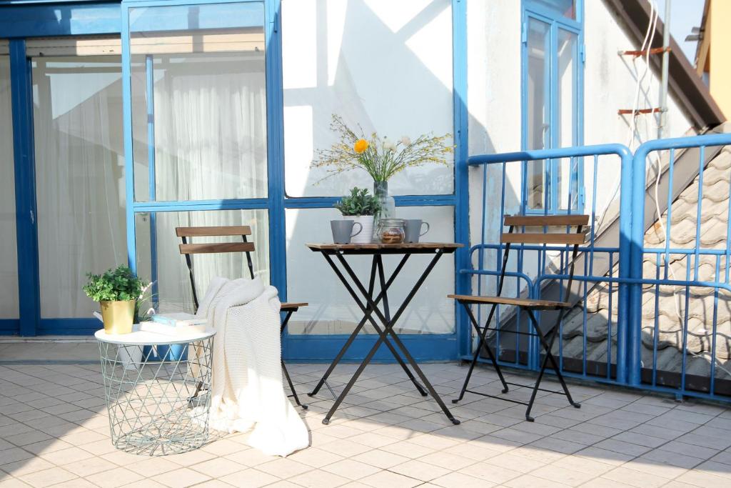 a table and chairs on a balcony with a blue wall at Yourbanflat Turazza in Padova